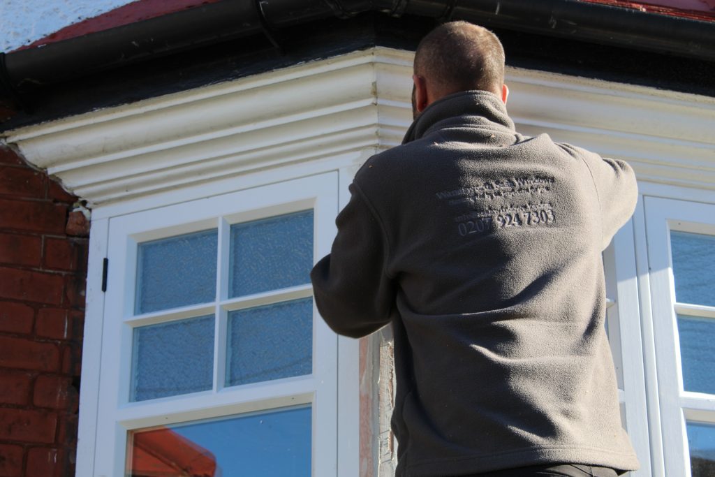 Workman working on removing sash windows at height