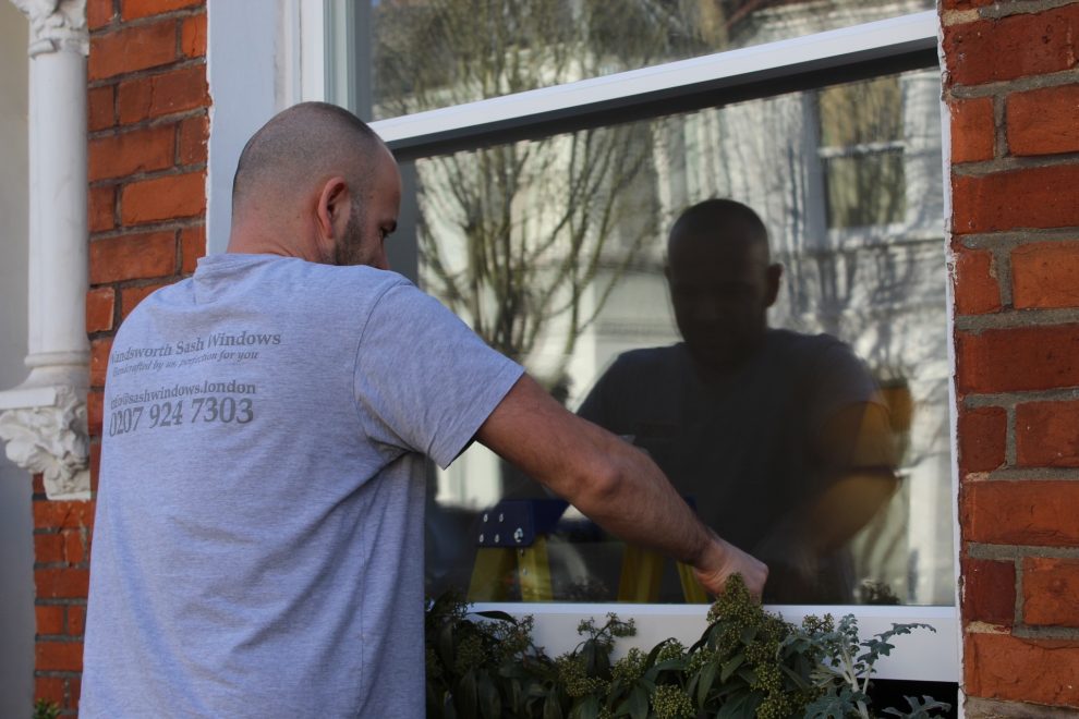 Carpenter installing sash windows