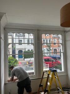 Workman inspecting sash windows for safety