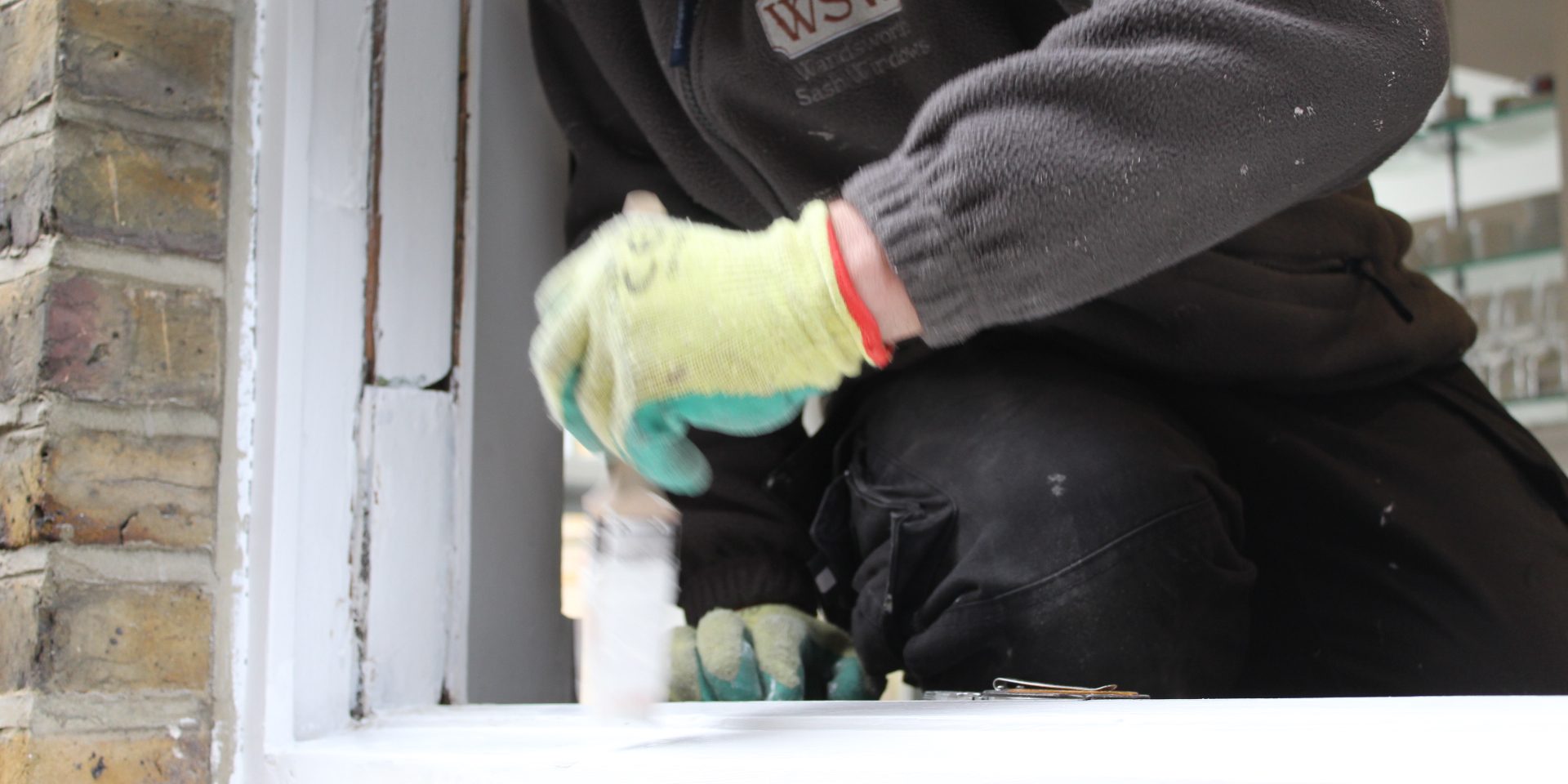 Workman restoring the paint on sash windows