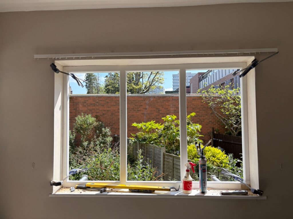 Installation of timber casement window in progress