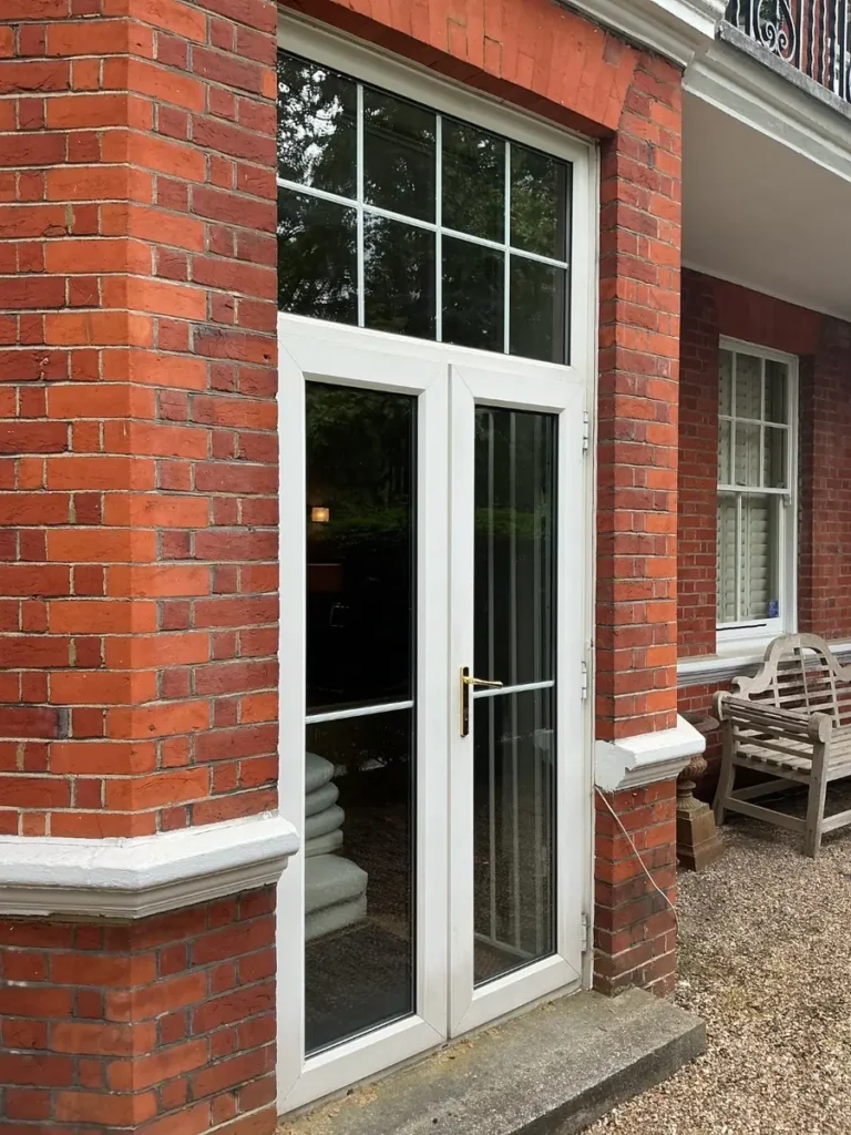 Old uPVC French doors in a red brick bay, Prince of Wales Drive, Battersea